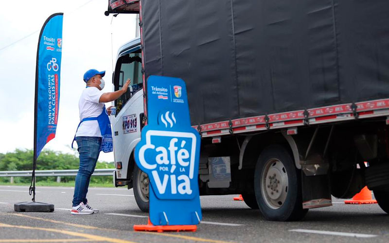 Fotografía de camión recibiendo un café por la vida