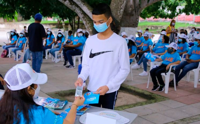 Fotografía joven recibiendo preservativo en campaña de prevención de embarazo