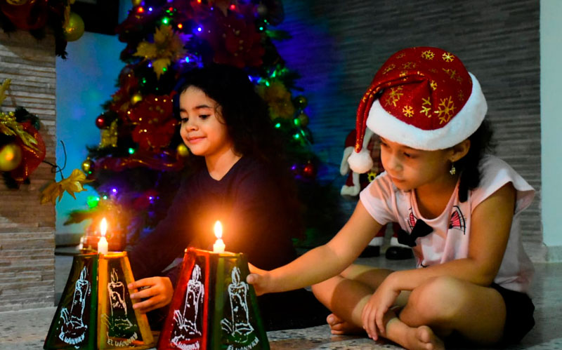 Fotografía Niñas encendiendo velitas